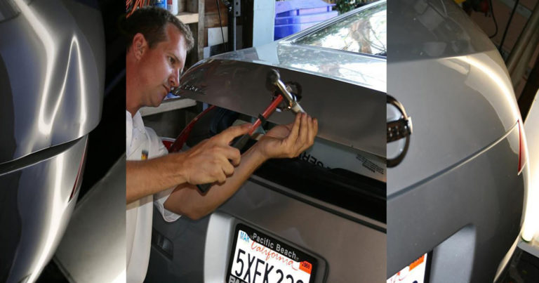 A man working on the hood of an automobile.