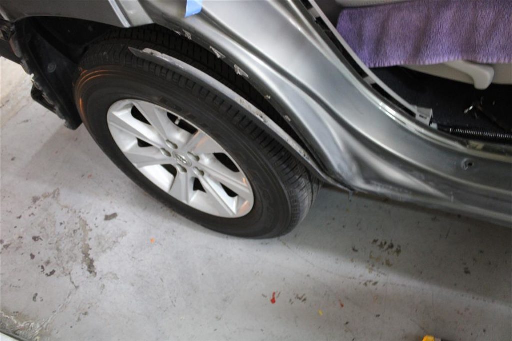 A car tire on the ground in a garage.