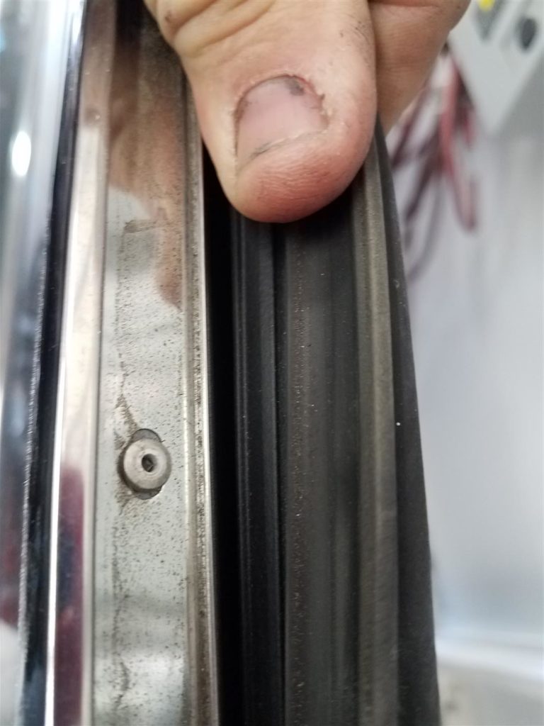 A person holding the edge of a door.