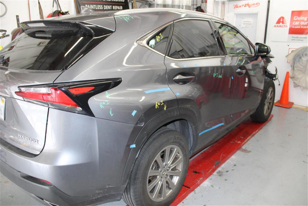 A car is parked in the garage with some paint on it.
