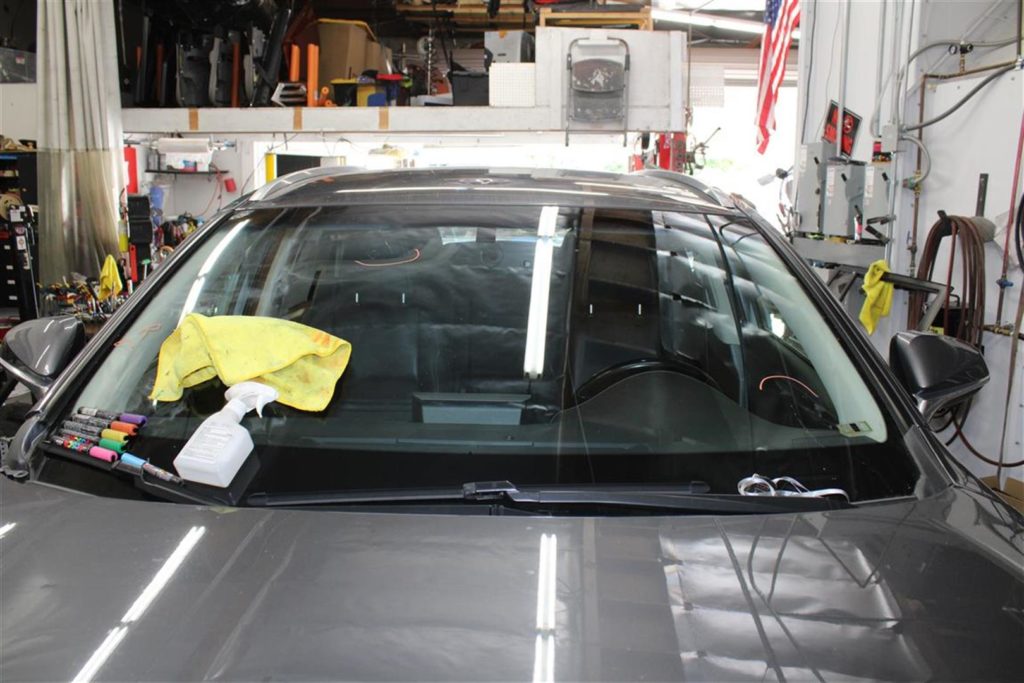 A car with a yellow cloth on it's windshield.