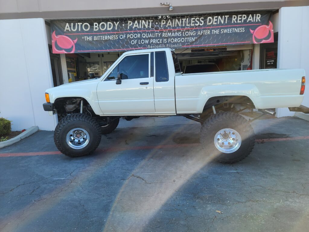 A white truck parked in front of a building.