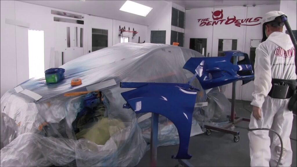 A car body being painted in a shop.