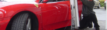 A man is working on the car of his ferrari.