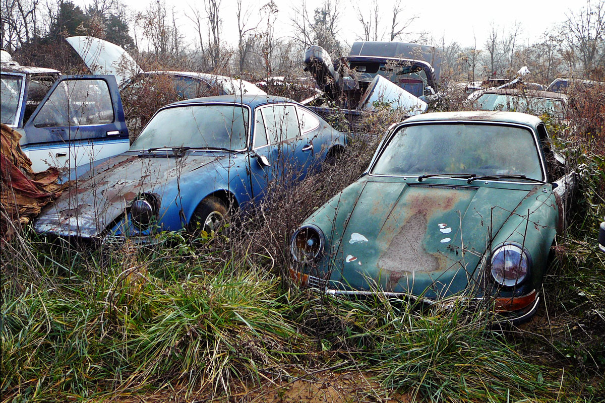 A group of old cars that are in the grass.