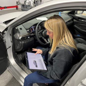 A woman sitting in the driver 's seat of a car.