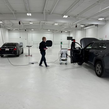 A man is walking in front of some cars