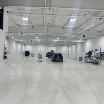 A large room with several cars parked in it.