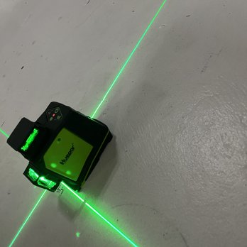 A green laser is being used to measure the distance.